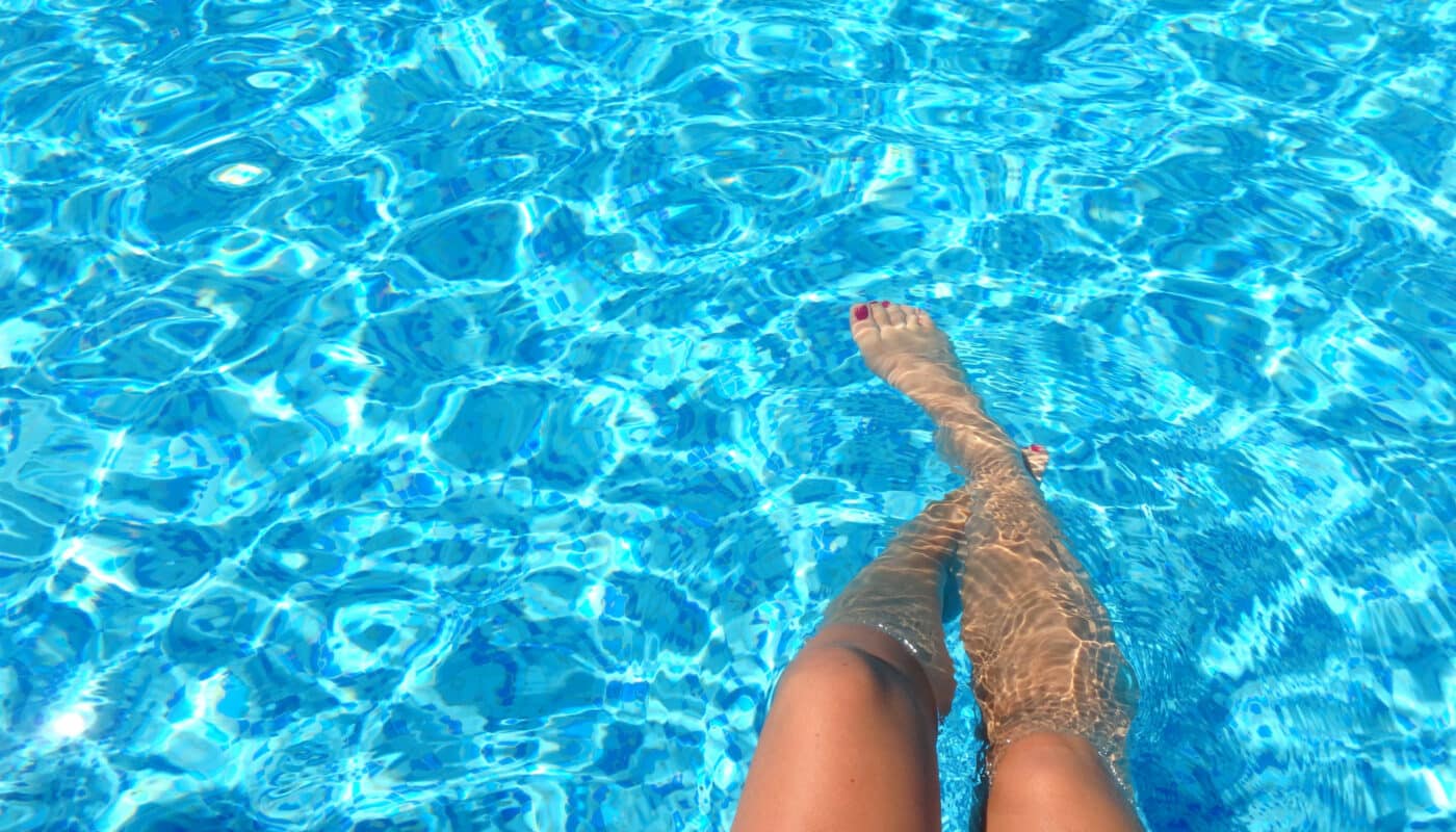 pieds de femme qui trempent dans la piscine