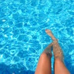 pieds de femme qui trempent dans la piscine