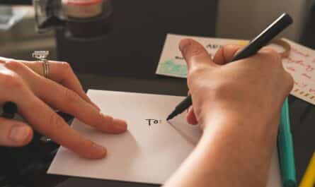 Mains de femme qui écrivent une adresse sur une enveloppe