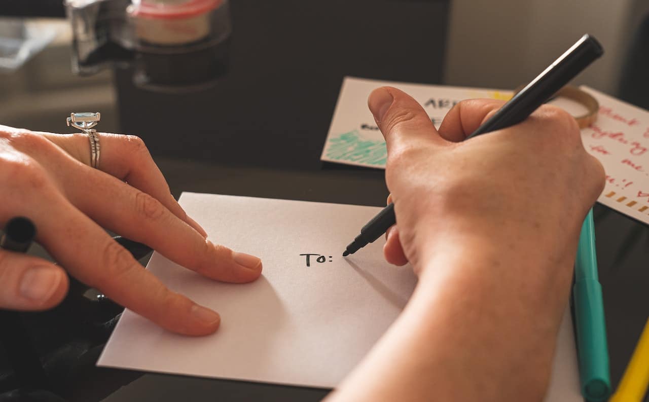 Mains de femme qui écrivent une adresse sur une enveloppe